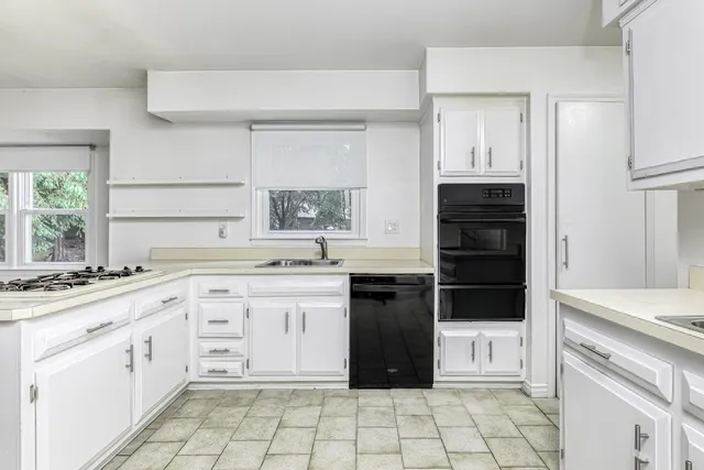 a kitchen with a stove sink and cabinets