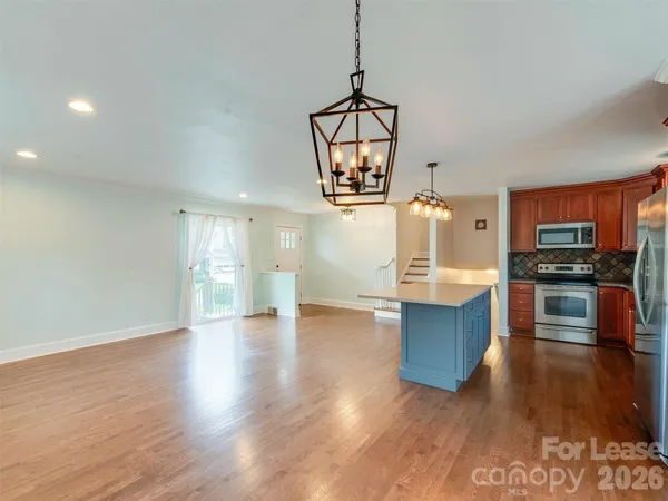 a view of a kitchen with microwave and wooden floor