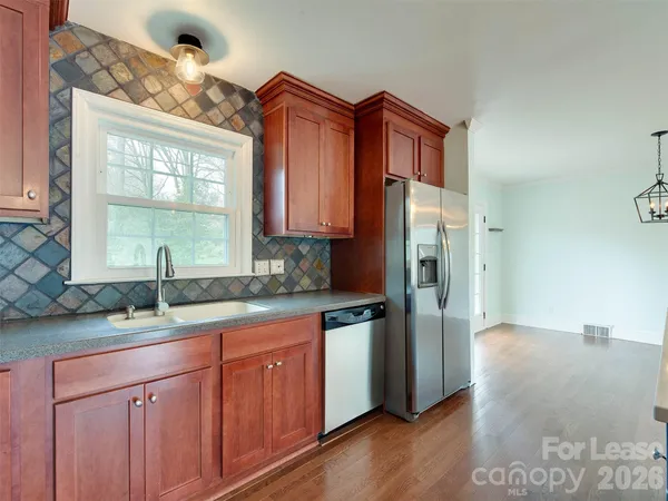 a kitchen with stainless steel appliances granite countertop a refrigerator and a sink