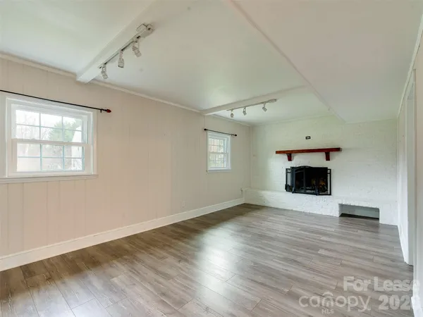 a view of an empty room with a window and fireplace