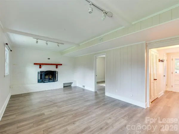 a view of an empty room with a fireplace and a window