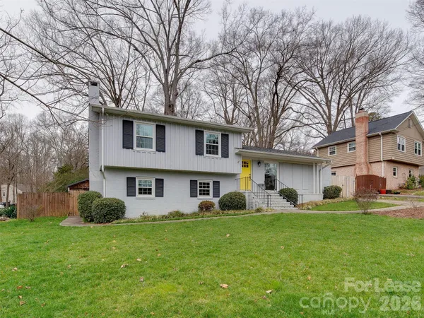 a front view of a house with a yard and trees