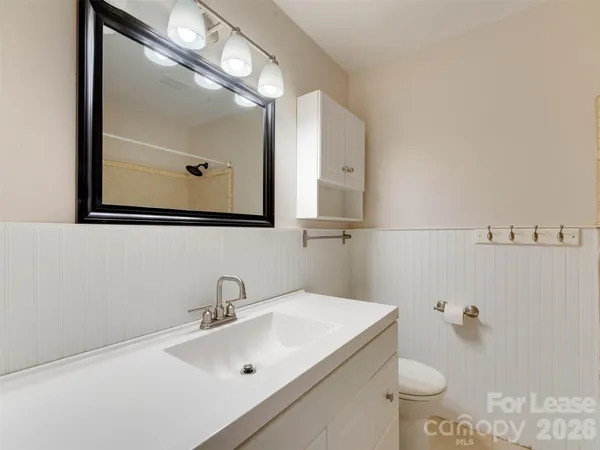 a bathroom with a sink and mirror with toilet