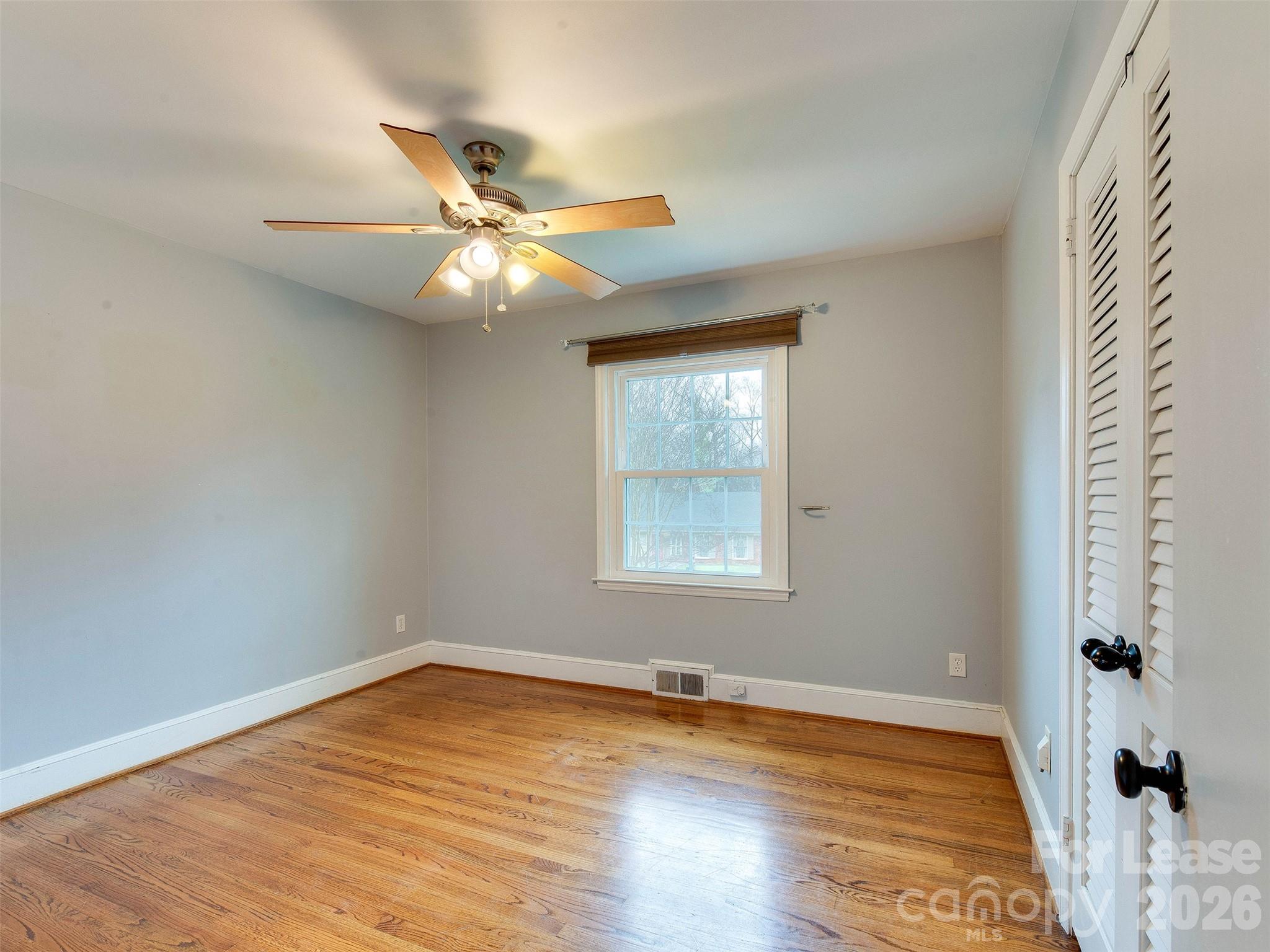 7026 Morganford Road Charlotte, NC 28211 - Photo 29 of 48 an empty room with wooden floor fan and windows