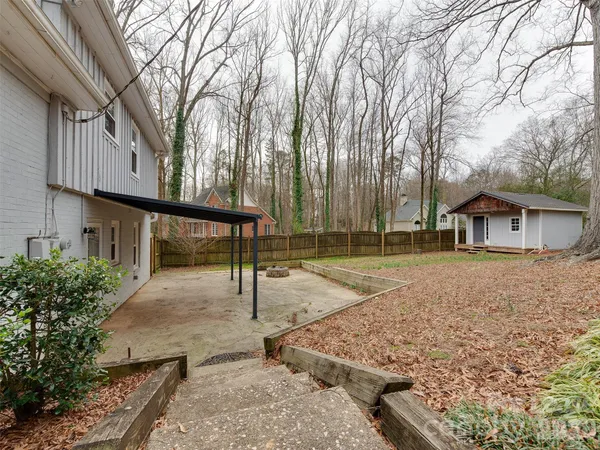 a view of a house with backyard and wooden fence