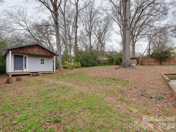 a view of backyard with a barn and wooden fence
