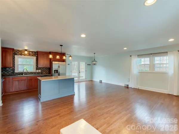 a view of large kitchen with wooden floor and large windows
