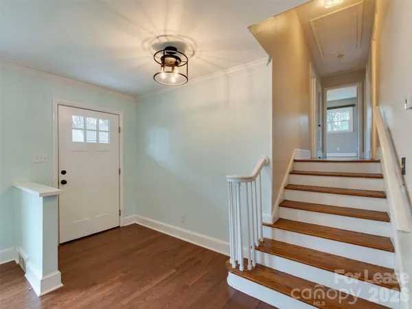 a view of a hallway with wooden floor and staircase