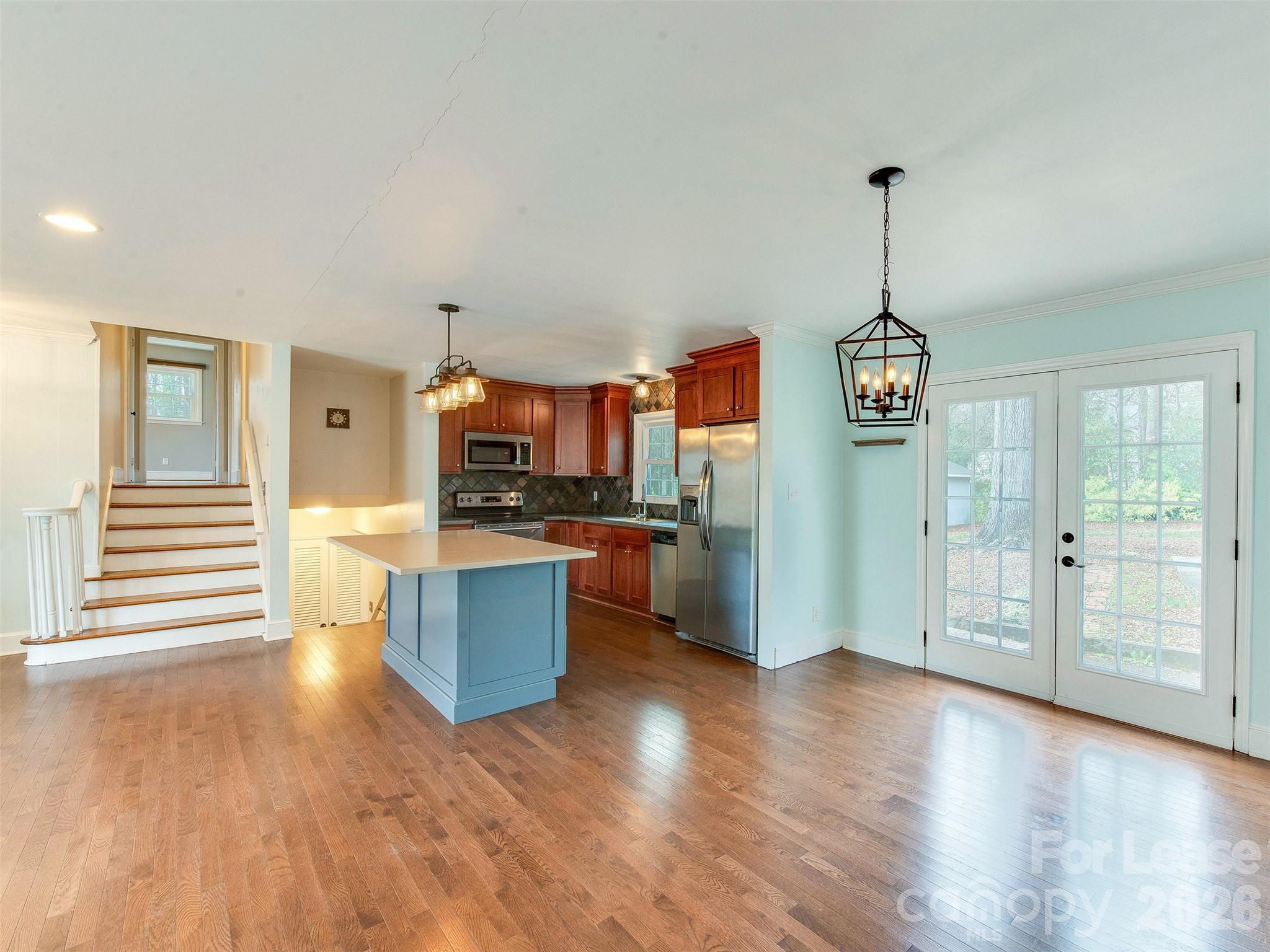 7026 Morganford Road Charlotte, NC 28211 - Photo 10 of 48 a kitchen with stainless steel appliances kitchen island granite countertop a refrigerator a stove and a wooden floors