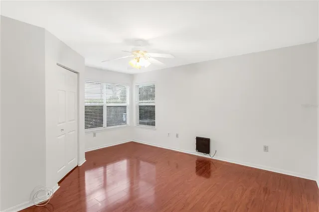an empty room with a window and wooden floor