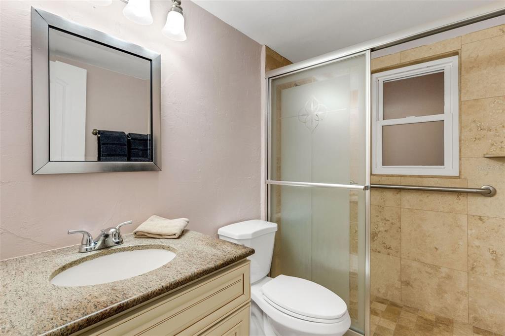 12760 Indian Rocks Road, Unit 119 Largo, FL 33774 - Photo 16 of 24 a bathroom with a granite countertop sink toilet a mirror and shower