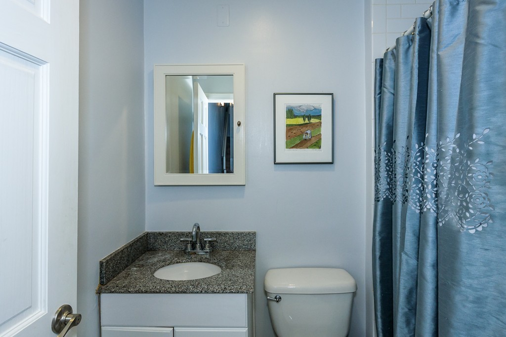120 Beaconsfield Road, Unit T6 Brookline, MA 02445 - Photo 12 of 14 a bathroom with a granite countertop sink toilet and a mirror