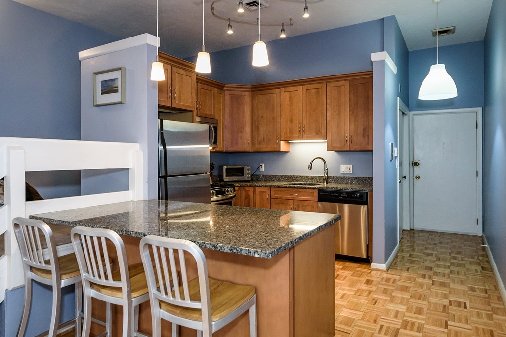 120 Beaconsfield Road, Unit T6 Brookline, MA 02445 - Photo 3 of 14 a kitchen with granite countertop kitchen island stainless steel appliances a stove sink and microwave