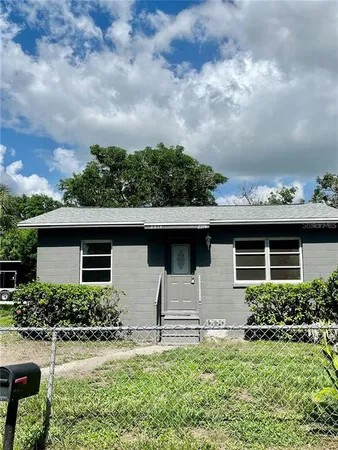 a front view of house with yard and trees around