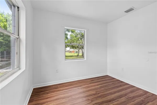 a view of a room with wooden floor and windows