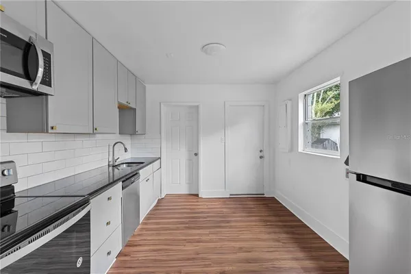a kitchen with stainless steel appliances granite countertop a sink stove and refrigerator