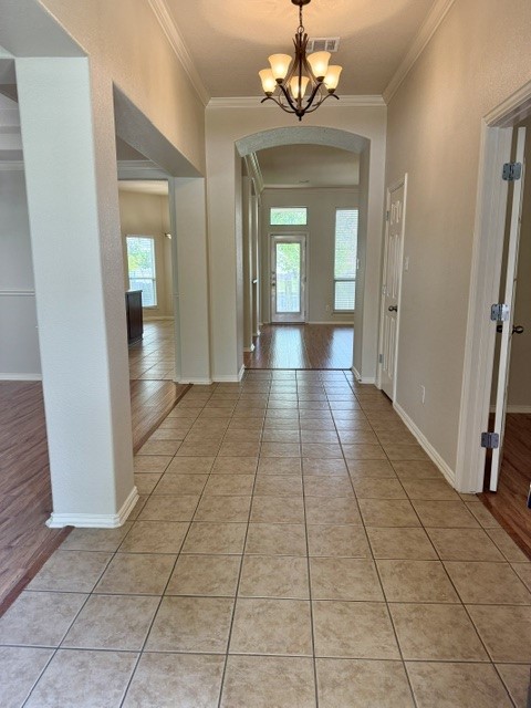 20724 Kearney Hill Road Pflugerville, TX 78660 - Photo 6 of 40 Entry foyer featuring square tile flooring, a bronze chandelier, arched doorways, and crown molding