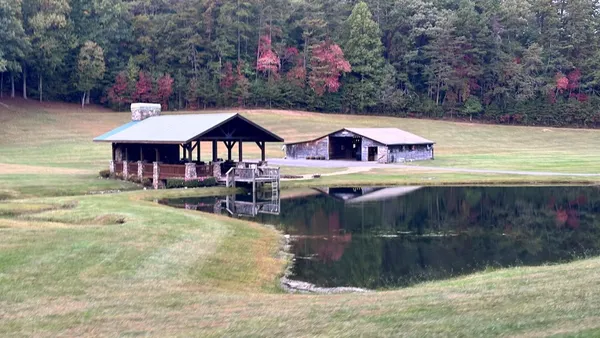 a view of a swimming pool with a patio and a yard