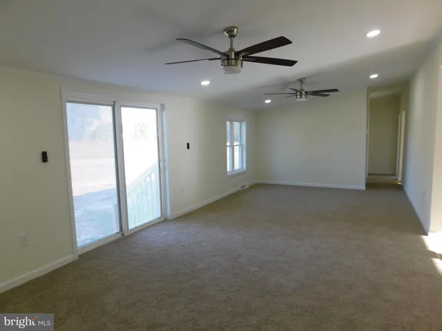 en empty room with windows and ceiling fan