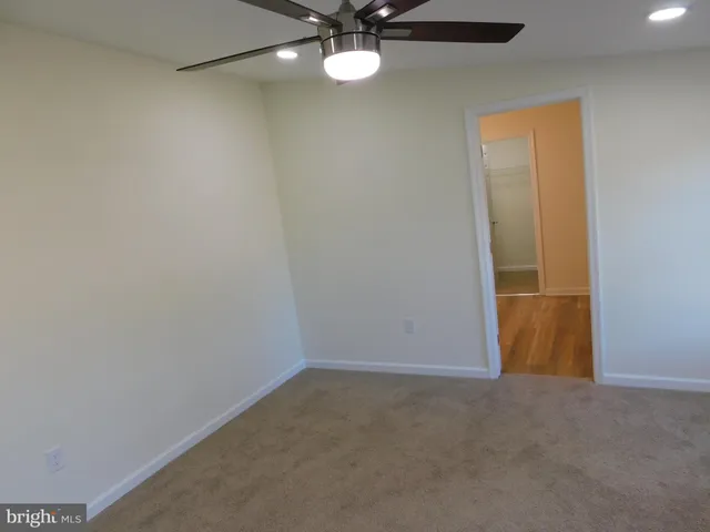 an empty room with a ceiling fan and a window