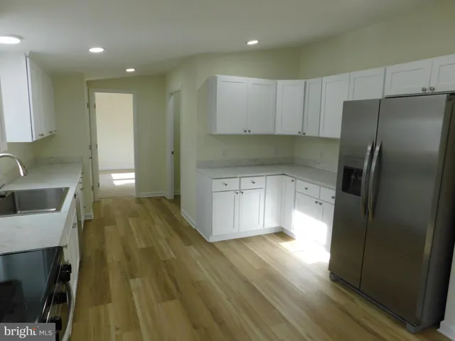a kitchen with a sink a refrigerator a stove and cabinets