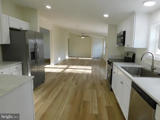 a view of a kitchen with a sink and refrigerator