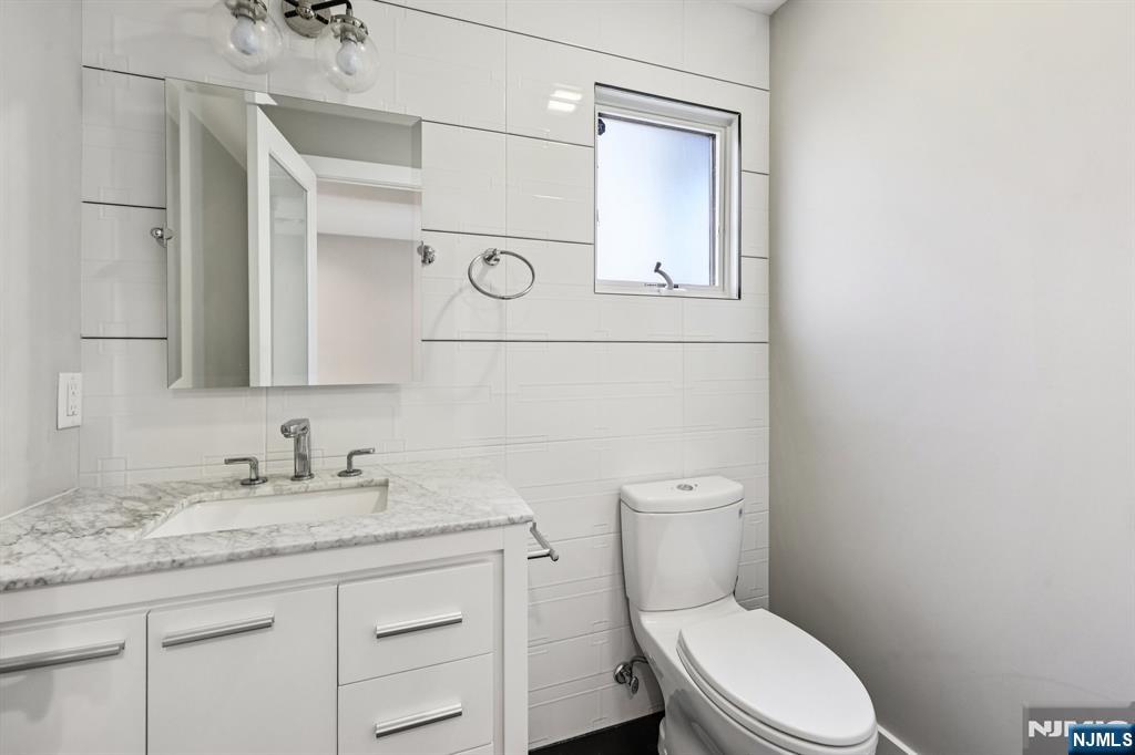 746 Undercliff Avenue, Unit B Edgewater, NJ 07020 - Photo 33 of 50 a bathroom with a granite countertop toilet sink and mirror