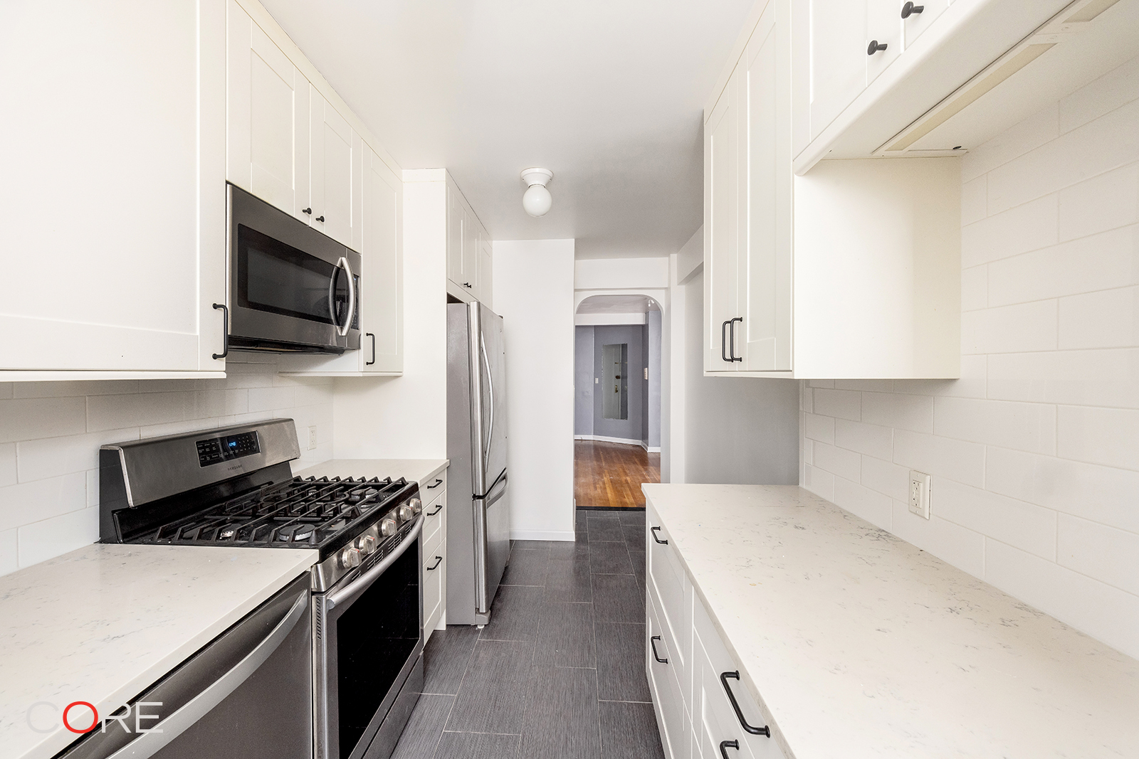 76-10 34th Avenue, Unit 3B Queens, NY 11372 - Photo 3 of 8 a kitchen with a stove and a refrigerator