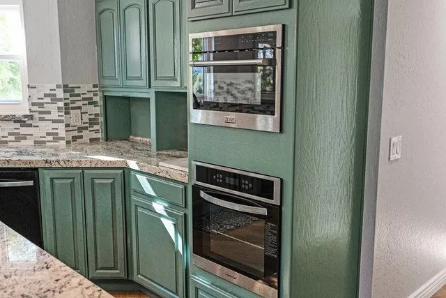 a bathroom with a granite countertop toilet sink and mirror