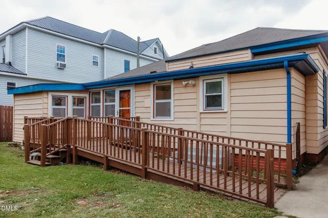 a view of a house with a yard and deck