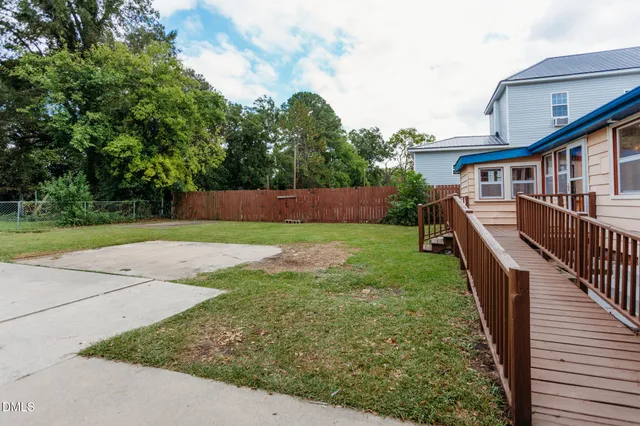 a view of a house with backyard and trees