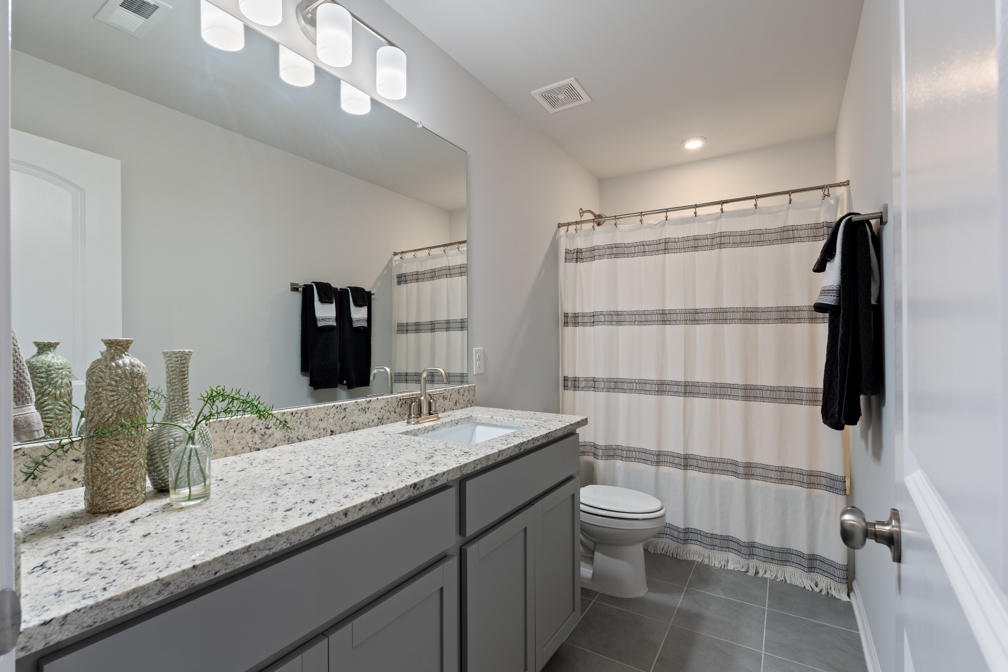 106 Pekka Drive Lebanon, TN 37087 - Photo 18 of 24 a bathroom with a granite countertop sink a toilet a mirror and shower