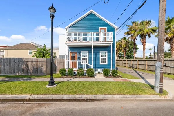 a front view of a house with a yard and potted plants