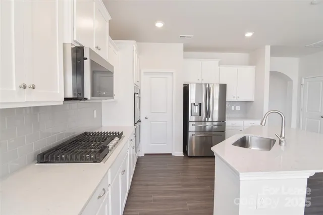 a kitchen with a sink stainless steel appliances and cabinets