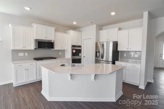 a kitchen with stainless steel appliances a refrigerator sink and microwave