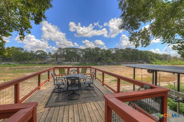 a balcony with wooden floor and outdoor seating