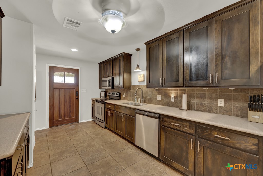 1015 Reiley Road Seguin, TX 78155 - Photo 3 of 41 a kitchen with stainless steel appliances granite countertop wooden cabinets a sink and dishwasher