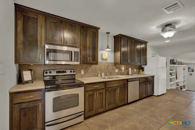 a kitchen with stainless steel appliances granite countertop a sink and stove top oven