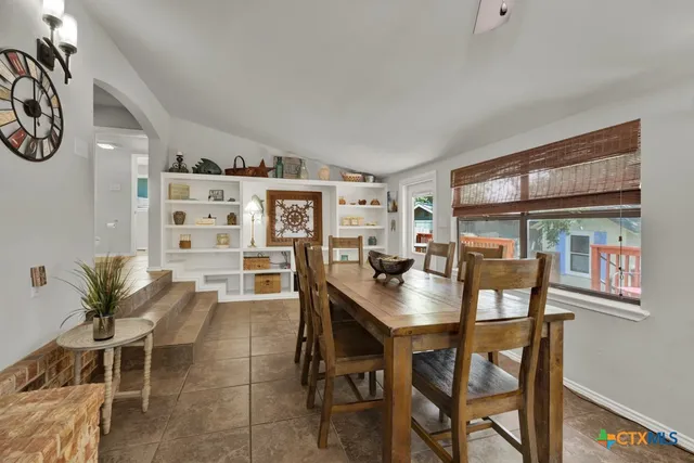 a dining room with a wooden table and chairs