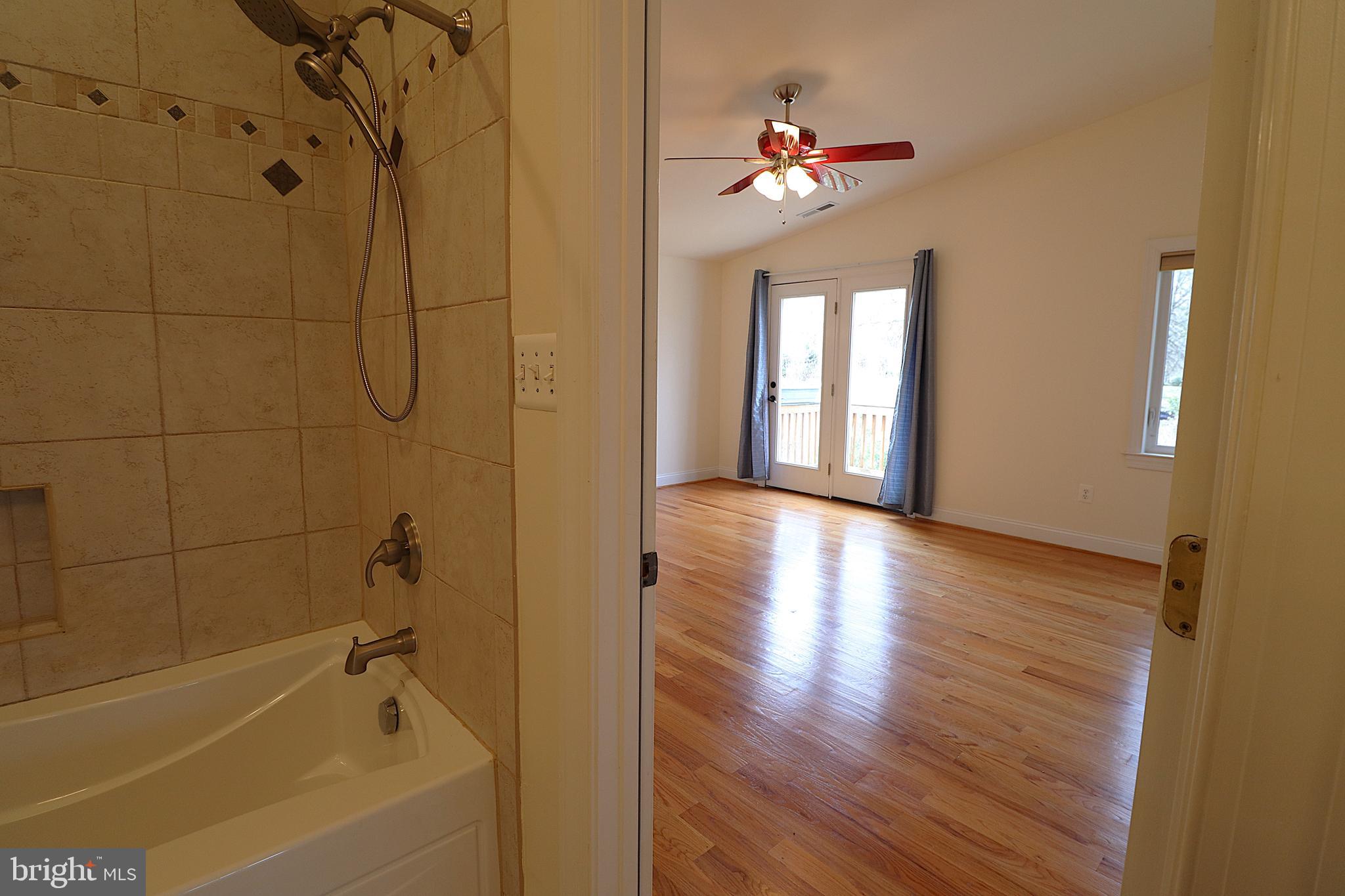 118 Quaint Acres Drive Silver Spring, MD 20904 - Photo 27 of 41 a view of a bathroom with a bathtub a ceiling fan and windows