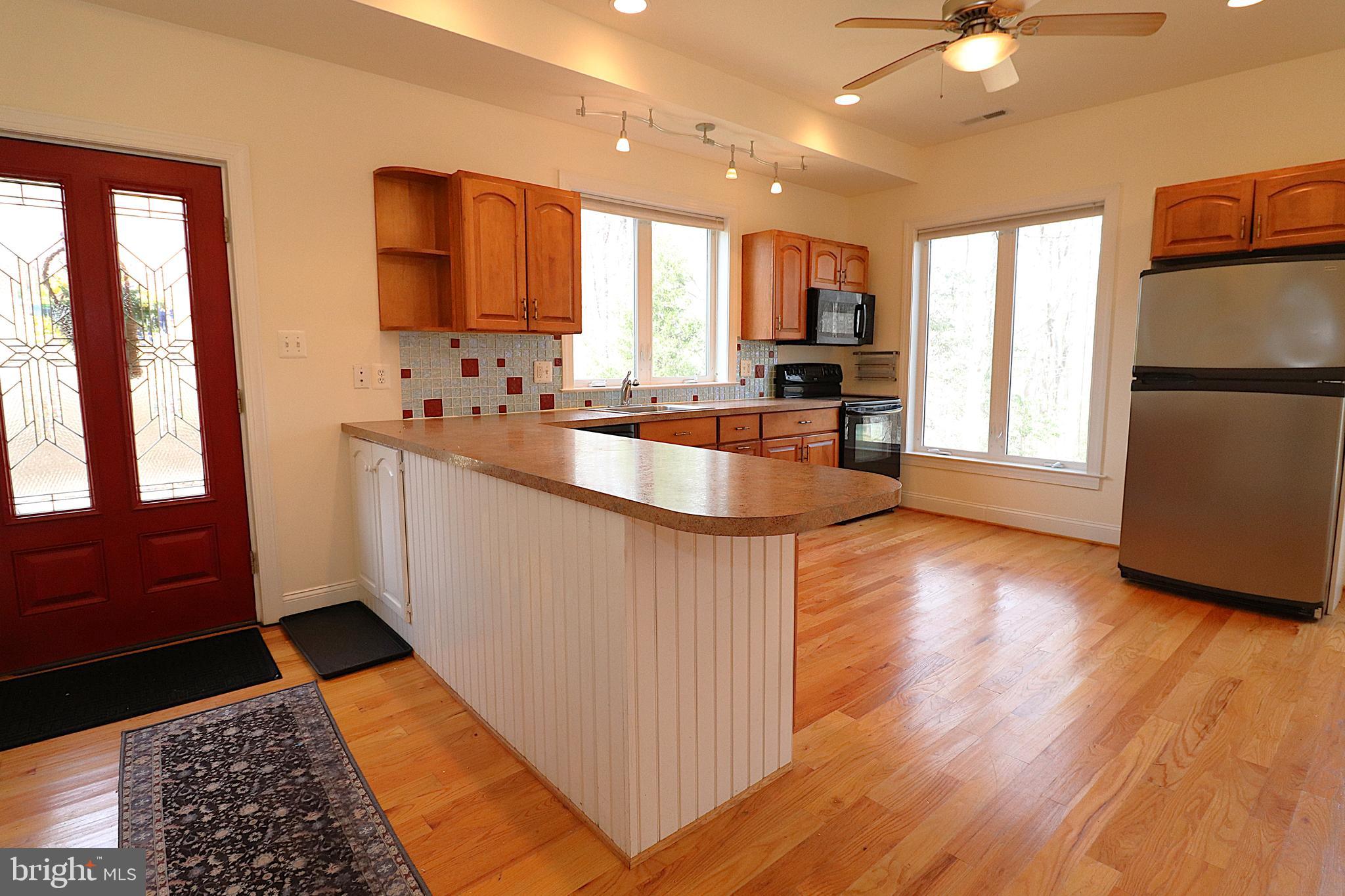 118 Quaint Acres Drive Silver Spring, MD 20904 - Photo 10 of 41 a kitchen with stainless steel appliances granite countertop a refrigerator a sink dishwasher a stove and white countertops with wooden floor