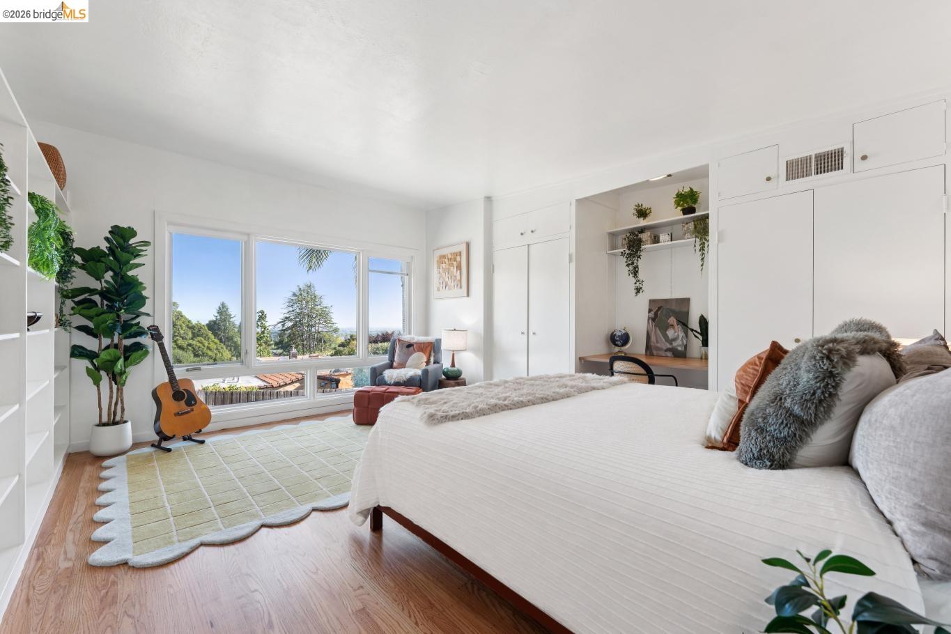 2301 Oak Street Berkeley, CA 94708 - Photo 11 of 61 Expansive windows showcasing a distant landscape, built-in shelving units, wood-finish flooring, and integrated cabinetry