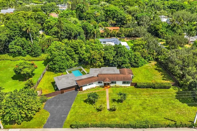 an aerial view of a house with yard swimming pool and outdoor seating