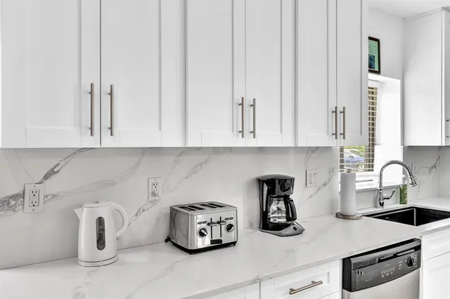 a kitchen with white cabinets and a sink
