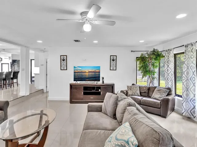 a living room with furniture a large window and a flat screen tv