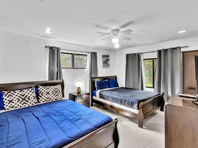 a bedroom with two beds and a large window