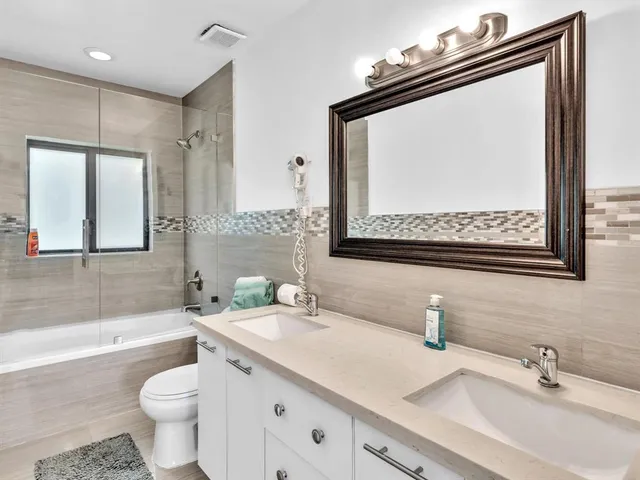 a bathroom with a sink vanity mirror and toilet
