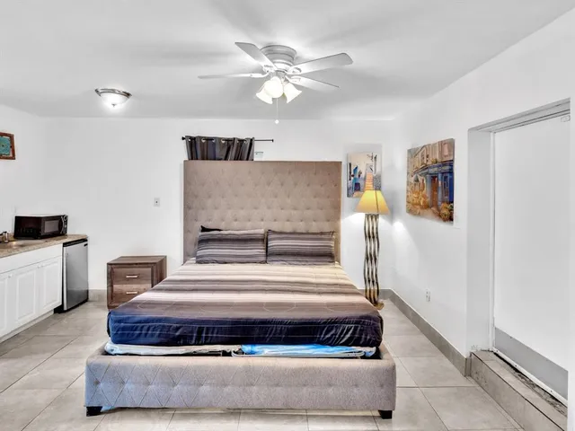 a spacious bedroom with a bed and a ceiling fan