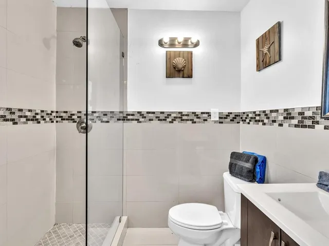 a bathroom with a toilet a sink and mirror