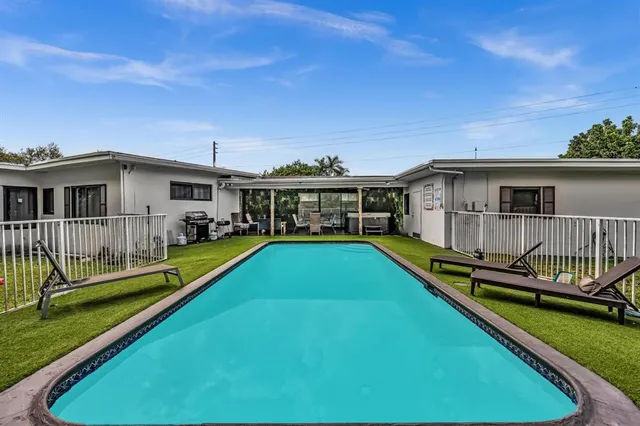 a view of a house with swimming pool and sitting area